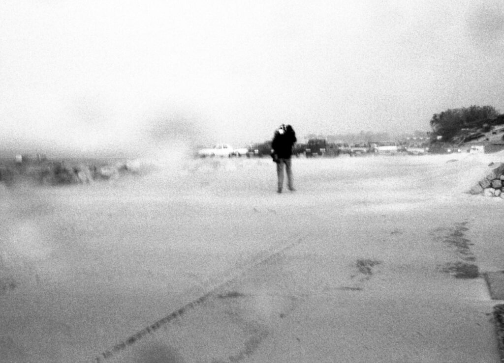 Schwarz-weiß Foto von einem Spaziergänger bei schlechtem Wetter
